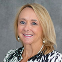 Sharon Ekern is wearing a black and white patterned shirt and has blonde hair