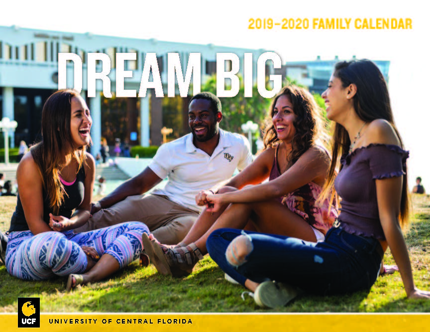 Students sitting on grass in front of Millican Hall with words "Dream Big" above their heads